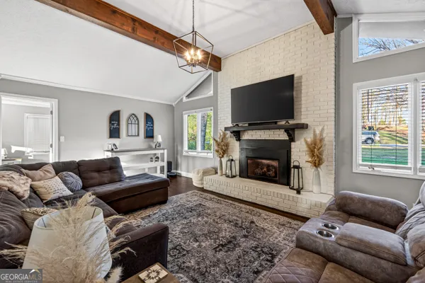 a living room with furniture a flat screen tv and a fireplace