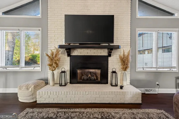 a living room with furniture a flat screen tv and a fireplace