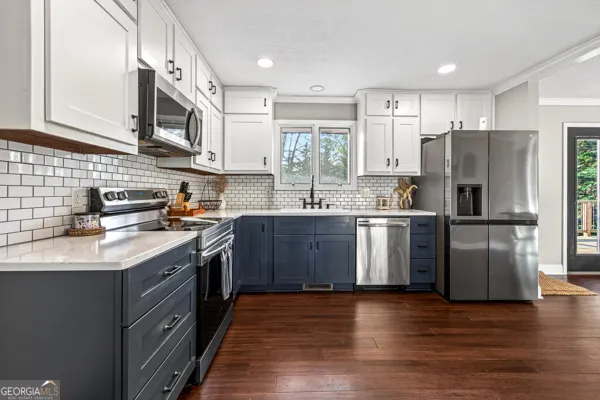 a kitchen with kitchen island granite countertop a sink stainless steel appliances and cabinets