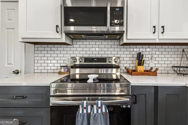 a kitchen with a stove a microwave a sink and cabinets