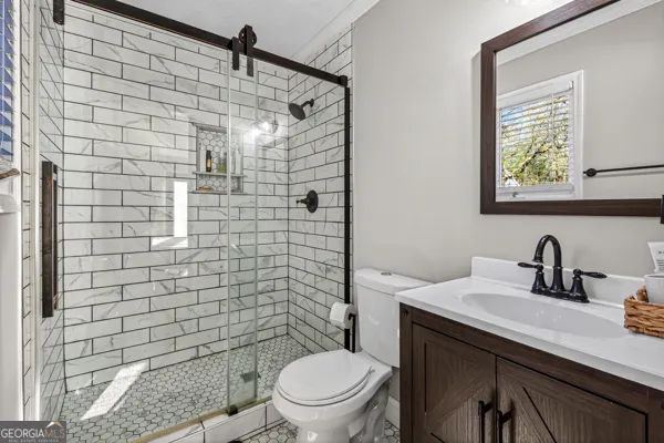 a bathroom with a sink a toilet and shower