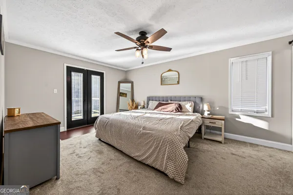 a spacious bedroom with a bed and a chandelier