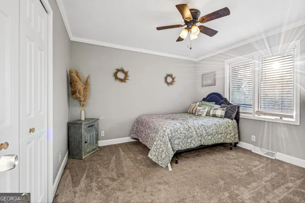 a bedroom with a bed and a ceiling fan