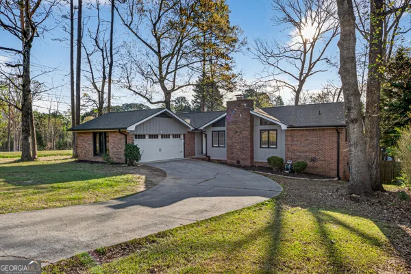 a view of a house with a yard and large tree