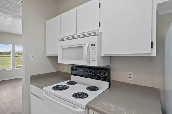 a kitchen with white cabinets and appliances