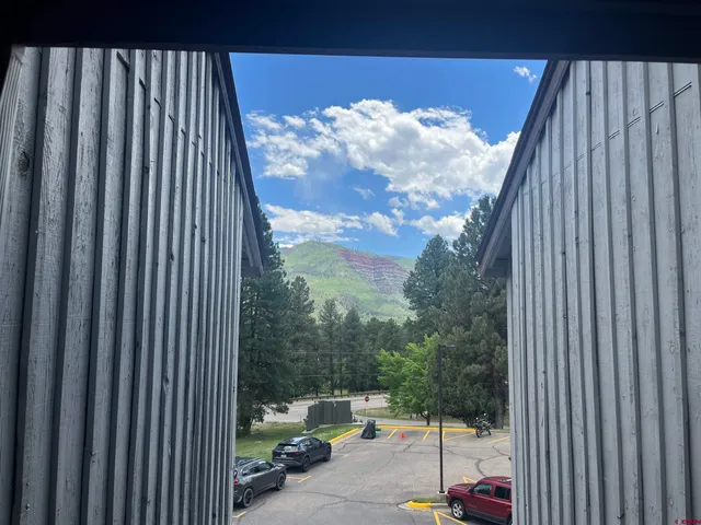 a view of a house with brick wall and plants