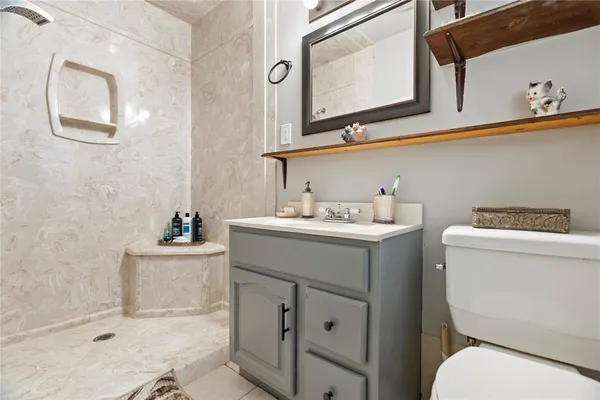 a bathroom with a toilet sink and mirror