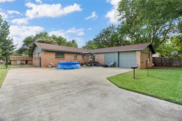 a front view of house with a garden and trees