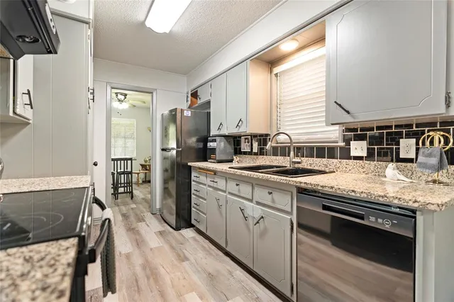 a kitchen with stainless steel appliances granite countertop a stove a sink and a refrigerator