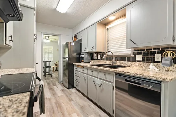 a kitchen with stainless steel appliances granite countertop a stove a sink and a refrigerator
