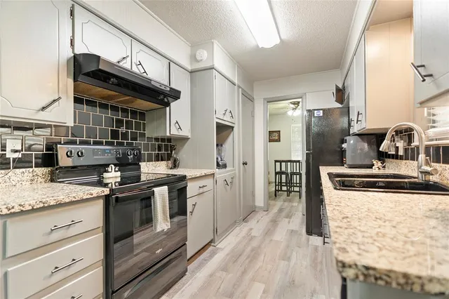 a kitchen with stainless steel appliances granite countertop a stove and a sink
