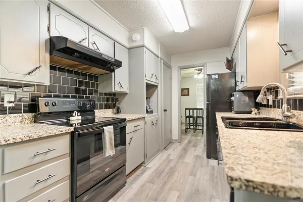 a kitchen with stainless steel appliances granite countertop a stove and a sink