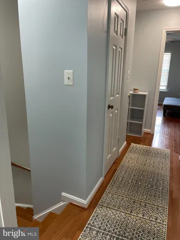 a view of a hallway with wooden floor and closet
