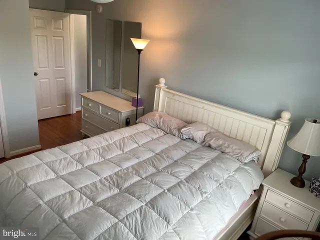 a bedroom with a bed and painting on the wall