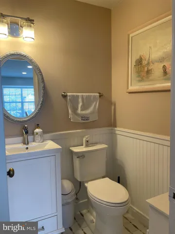 a bathroom with a toilet a sink and mirror