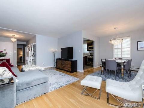 21 Bond Street, Unit 2K Great Neck, NY 11021 - Photo 1 of 1 a living room with furniture and a flat screen tv