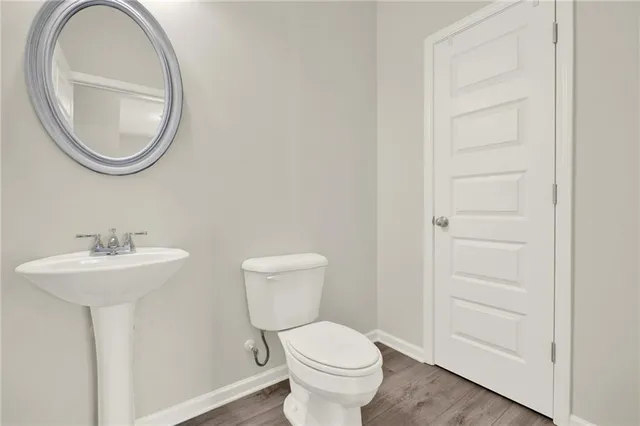 an empty room with wooden floor fireplace and windows