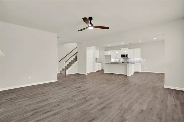 a view of an empty room with wooden floor fireplace and a window