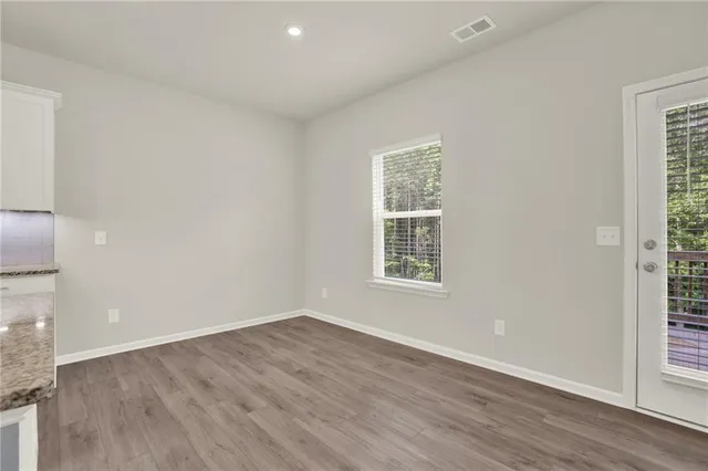 a large kitchen with kitchen island a island wooden floors stainless steel appliances and cabinets