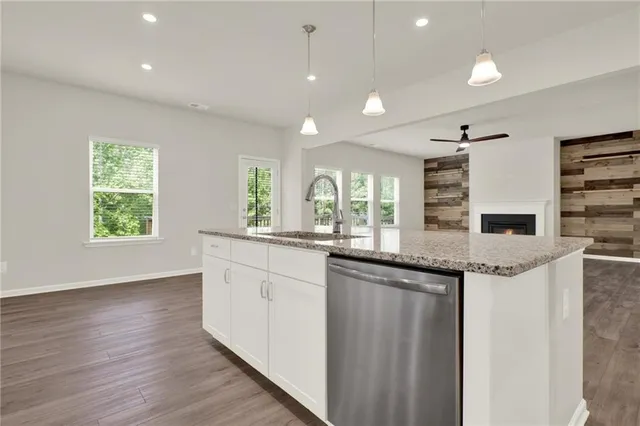 a kitchen with granite countertop white cabinets and stainless steel appliances