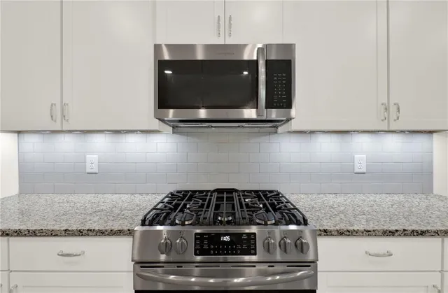 a kitchen with white cabinets and a wooden floor