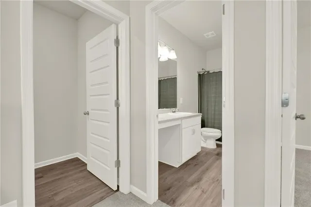 a bathroom with a sink a toilet and a large mirror