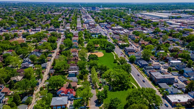 an aerial view of residential houses with outdoor space and trees all around