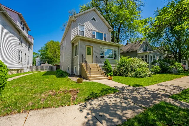 a front view of a house with a yard and trees