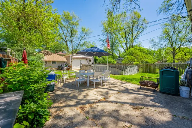 a view of a chair and table in backyard of the house