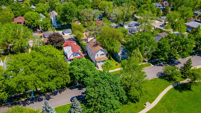 an aerial view of residential houses with outdoor space and trees all around