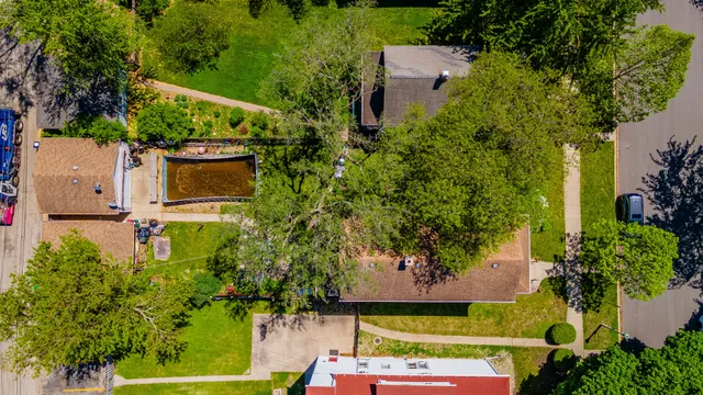 an aerial view of a house with a yard and large trees