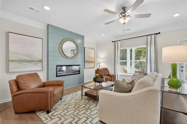a living room with furniture a fireplace and a large window
