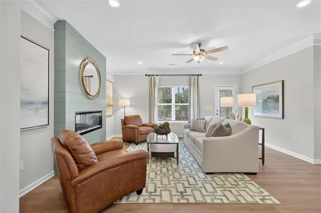 a living room with furniture a fireplace and a large window