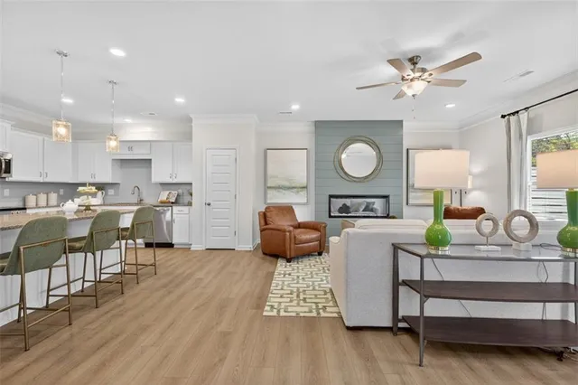 a living room with furniture kitchen and a wooden floor