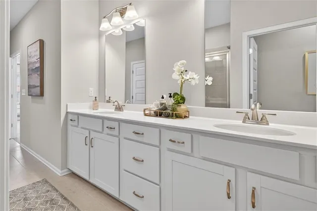 a bathroom with double vanity sinks a vanity a lamp and a mirror
