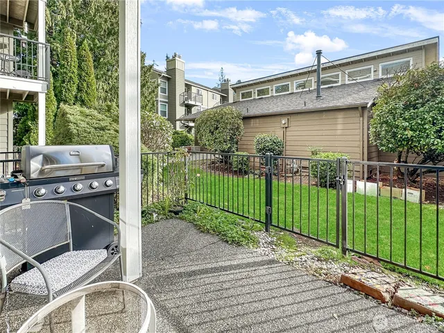 a view of a house with a small yard and wooden fence