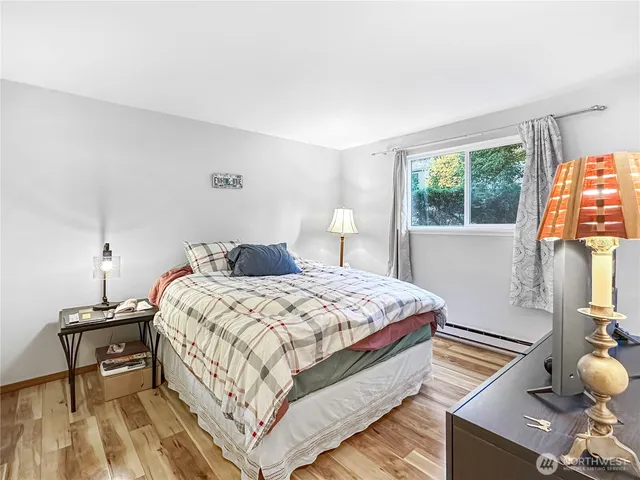 a bedroom with a bed and wooden floor