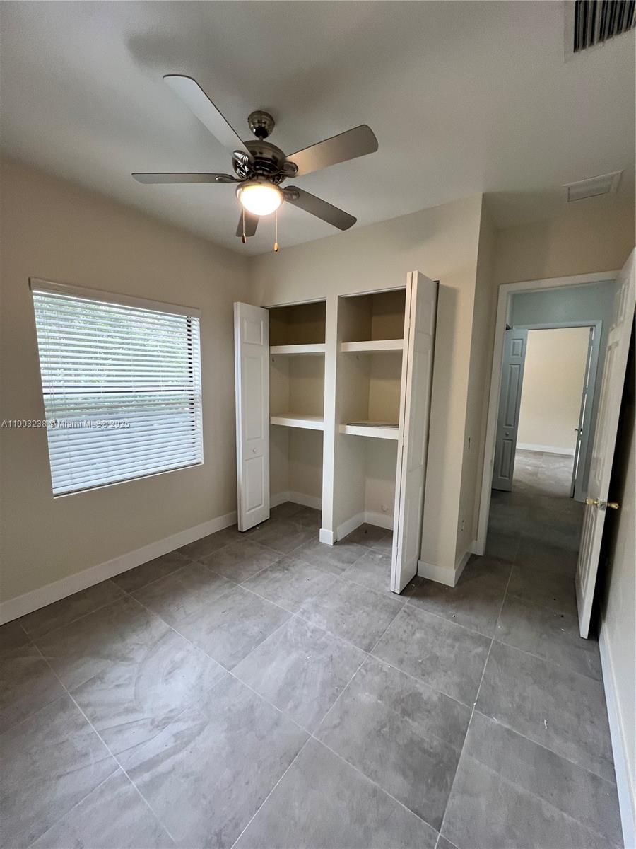10274 Southwest 180th Street, Unit 1 Miami, FL 33157 - Photo 12 of 17 an empty room with a empty space and a ceiling fan