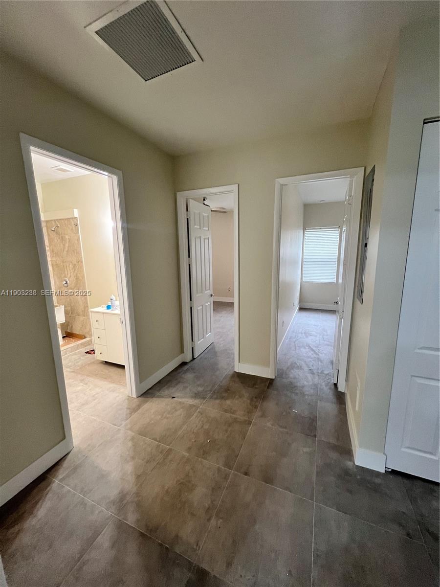 10274 Southwest 180th Street, Unit 1 Miami, FL 33157 - Photo 3 of 17 an empty room with mirror and a view of bathroom