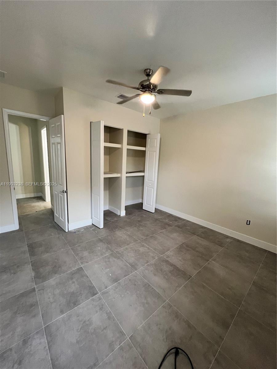10274 Southwest 180th Street, Unit 1 Miami, FL 33157 - Photo 8 of 17 a view of an empty room with a ceiling fan