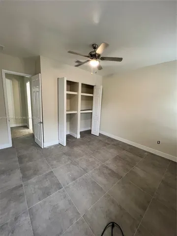 a view of an empty room with a ceiling fan