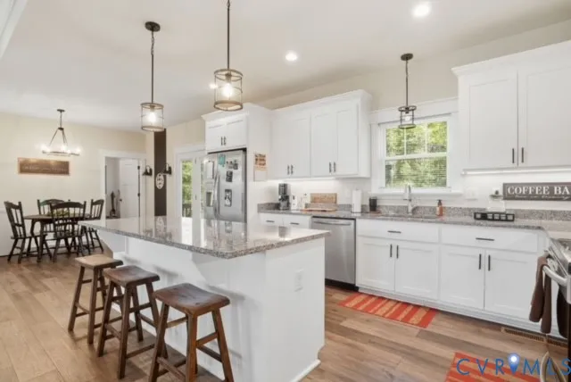 a living room with furniture kitchen view and a chandelier
