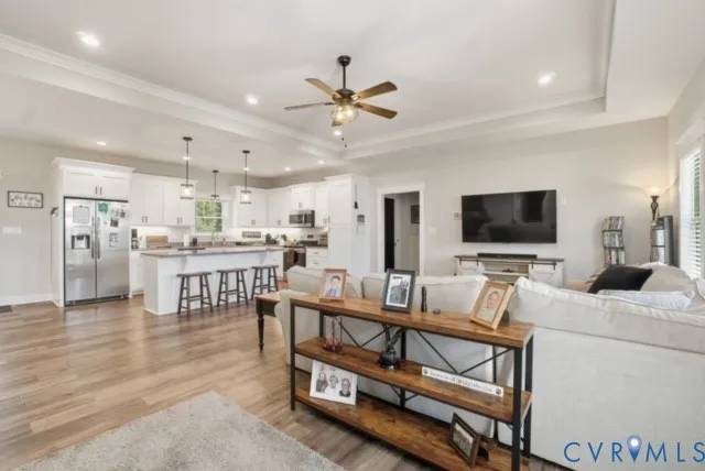 a living room with furniture a flat screen tv and kitchen view