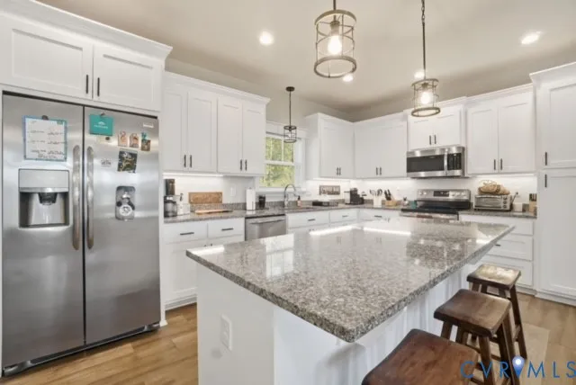 a kitchen with stainless steel appliances granite countertop a sink refrigerator and cabinets