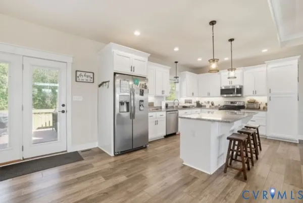 a kitchen with kitchen island white cabinets and refrigerator