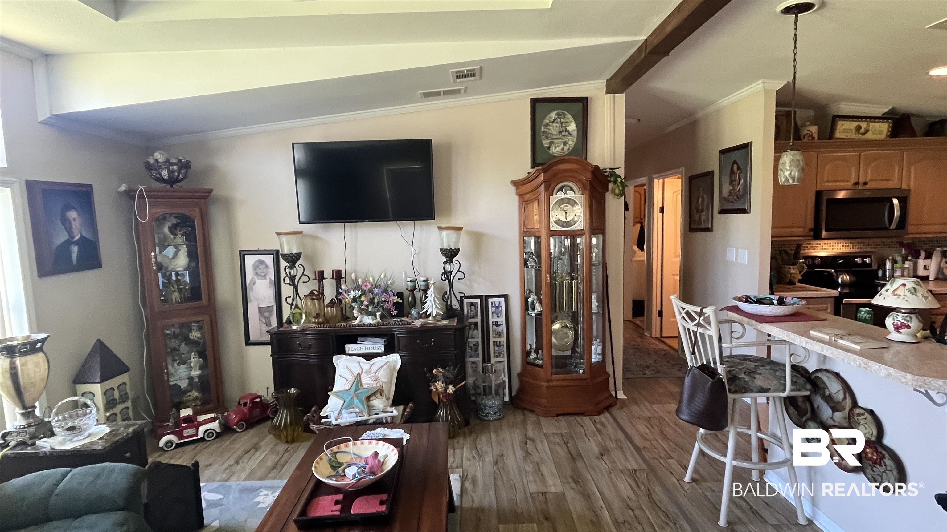 12932 Santa Piedro Street Lillian, AL 36549 - Photo 5 of 20 Living area with ornamental molding, lofted ceiling, and dark wood-style flooring