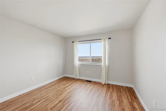 a view of a room with wooden floor and electronic appliances