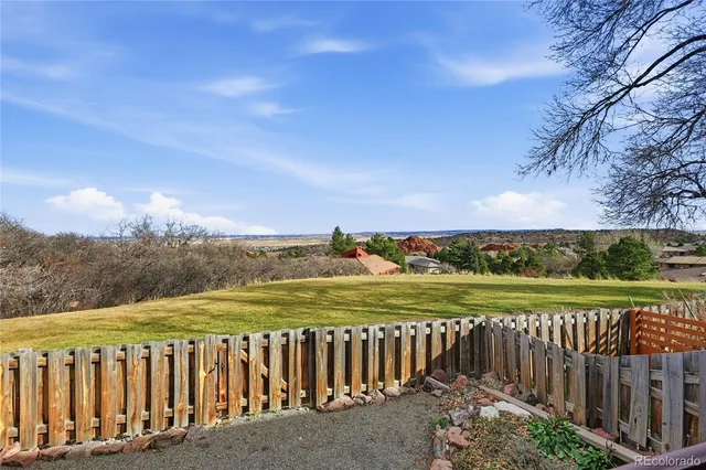 a view of a yard with wooden fence