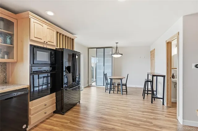 a open kitchen with stainless steel appliances a refrigerator and wooden floor
