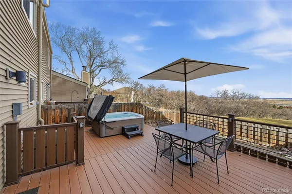 a view of a roof deck with table and chairs under an umbrella with wooden floor